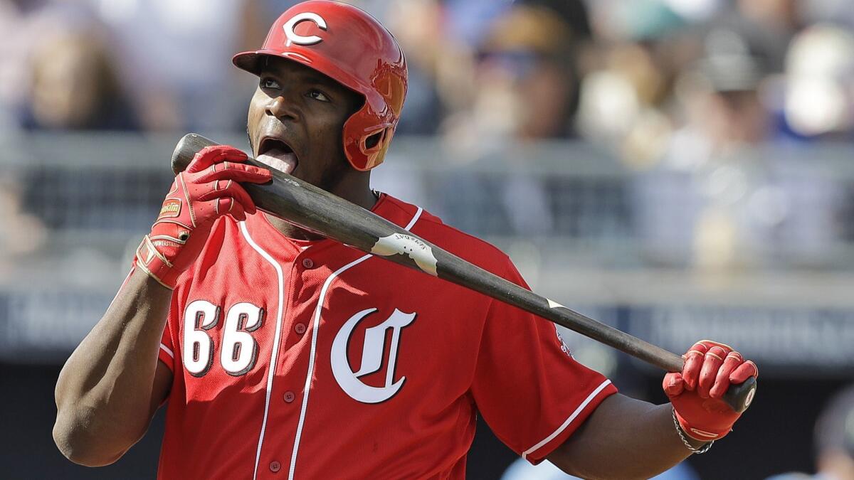 Cincinnati Reds' Yasiel Puig licks his bat during the third inning of a spring training game against the Seattle Mariners on Feb. 25 in Peoria, Ariz.