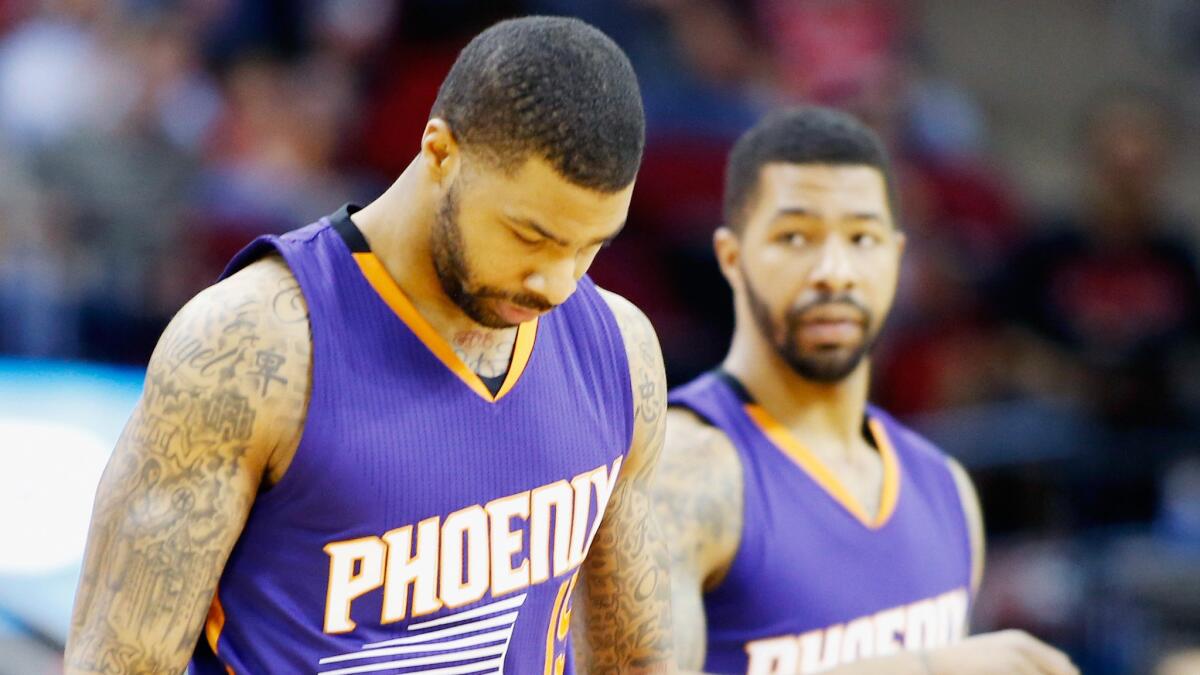 Brothers Marcus, left, and Markieff Morris of the Phoenix Suns walk onto the court before a game against the Houston Rockets on March 21.