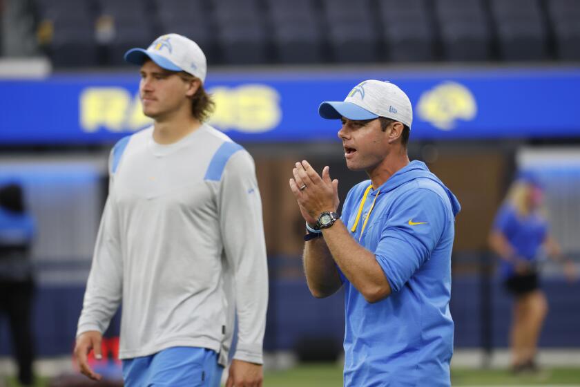 Los Angeles Chargers head coach Brandon Staley, right, claps next to quarterback Justin Herbert before a preseason NFL football game against the Los Angeles Rams Saturday, Aug. 14, 2021, in Inglewood, Calif. (AP Photo/Ringo Chiu )