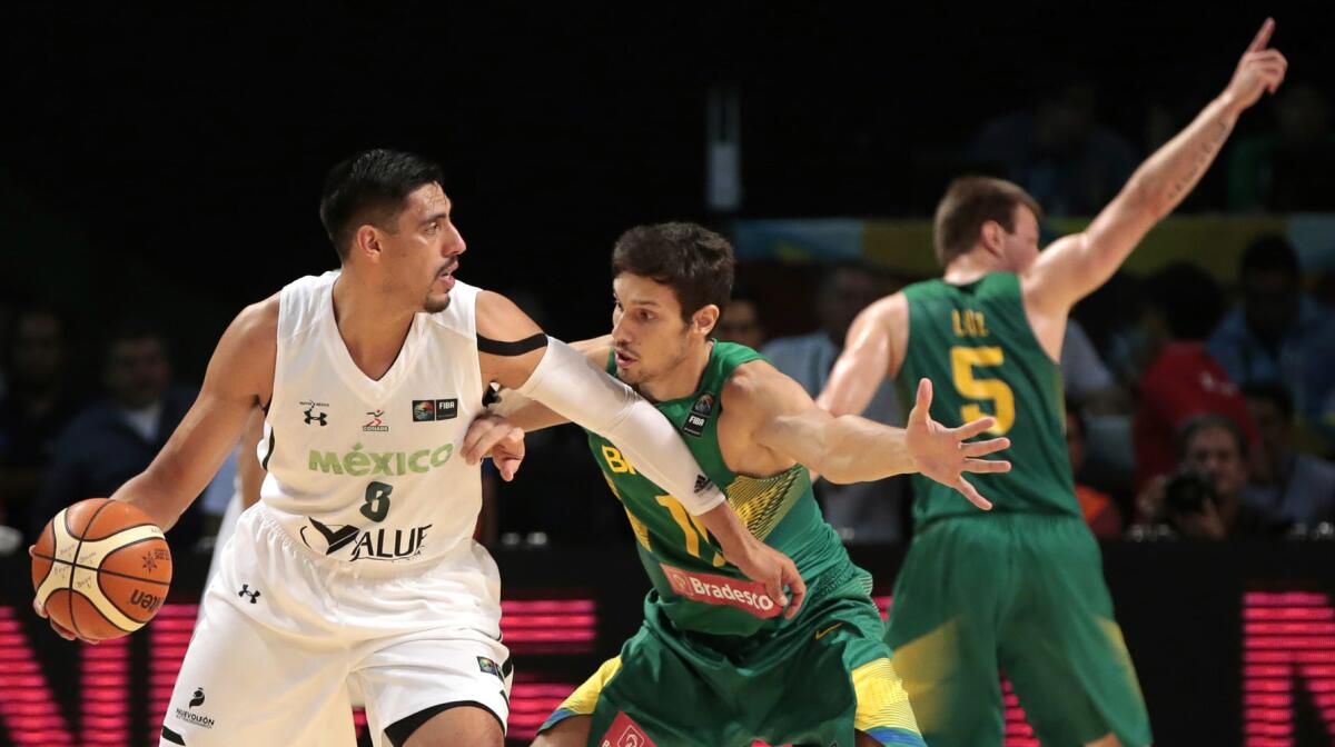 Rafael Mineiro (d) de Brasil, disputa el balón contra Gustavo Ayón (i) de México, en un juego del Torneo FIBA Américas, clasificatorio para los Juegos Olímpicos de Río de Janeiro 2016 en el Palacio de los Deportes en Ciudad de México.