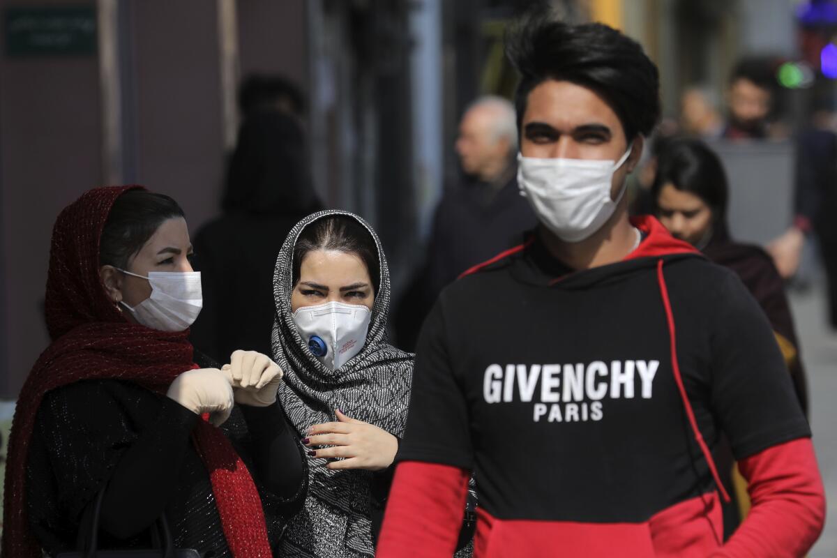 People wear masks in downtown Tehran on Sunday.