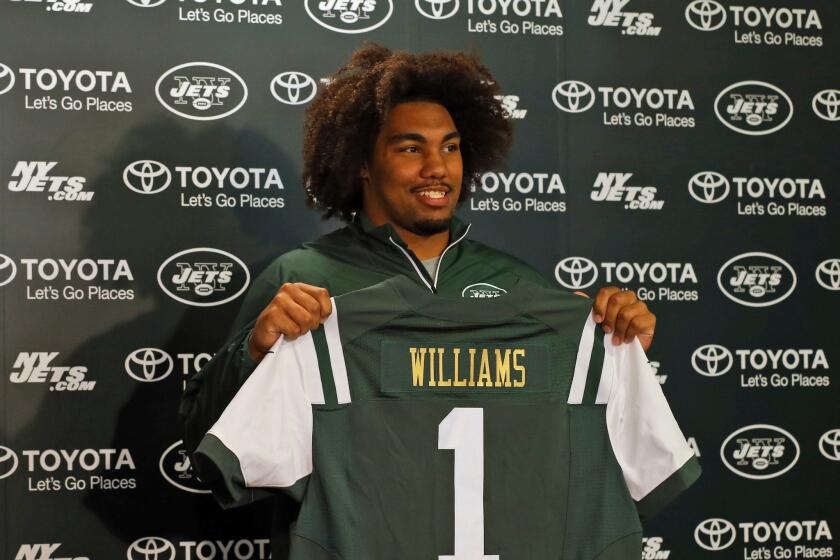 Former USC Trojan Leonard Williams holds up a New York Jets jersey as he is introduced to the media on Friday.