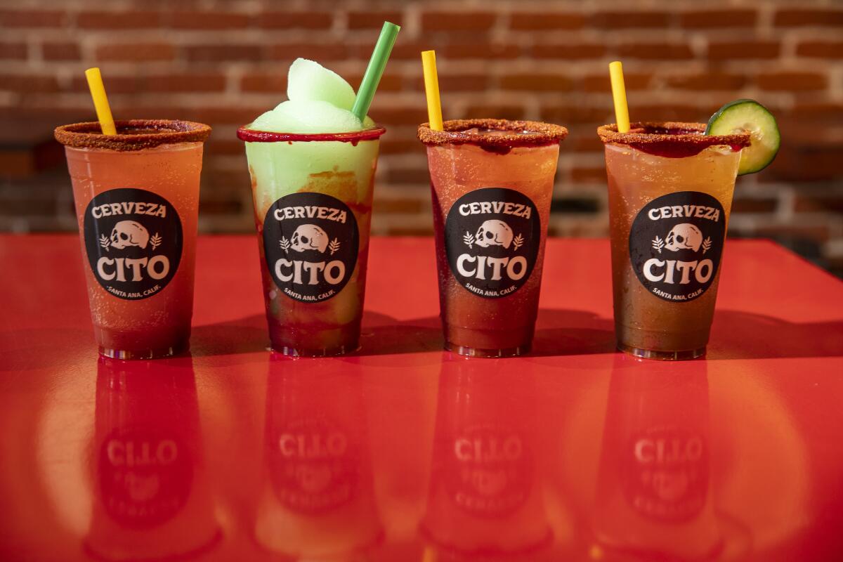 Four michelada drinks in plastic cups with labels featuring a skull and the words Cerveza Cito.