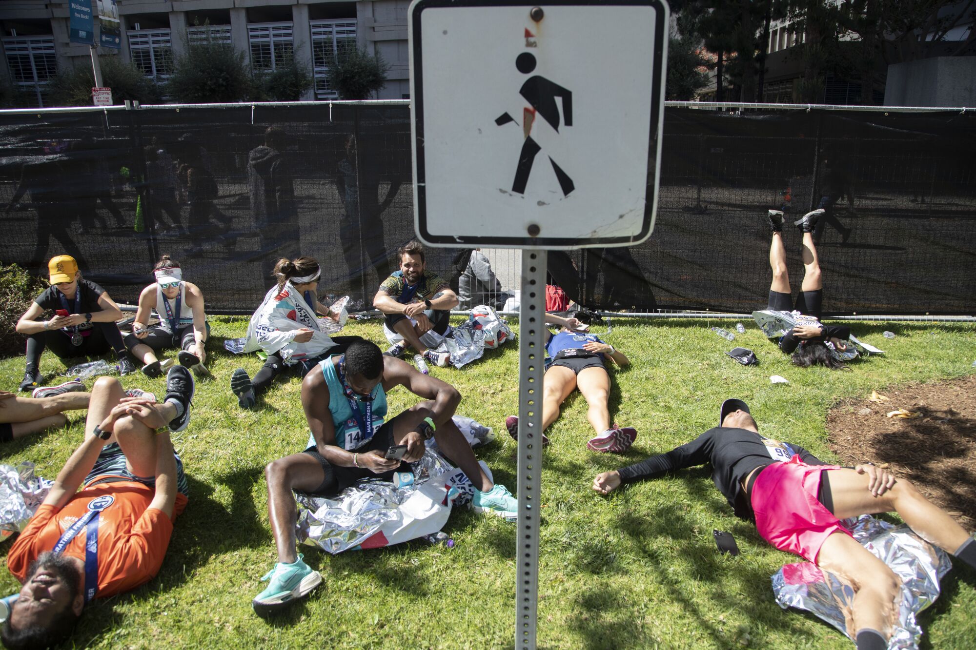 Runners rest on a grassy patch on the Avenue of the Stars after finishing the Los Angeles Marathon