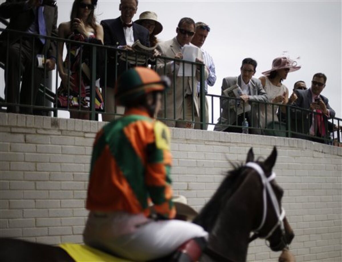 Spectators watch as Believe You Can ridden by Rosie Napravnik makes its way out to the track for the sixth race before the running of the 139th Kentucky Oaks at Churchill Downs Friday, May 3, 2013, in Louisville, Ky. (AP Photo/David Goldman)