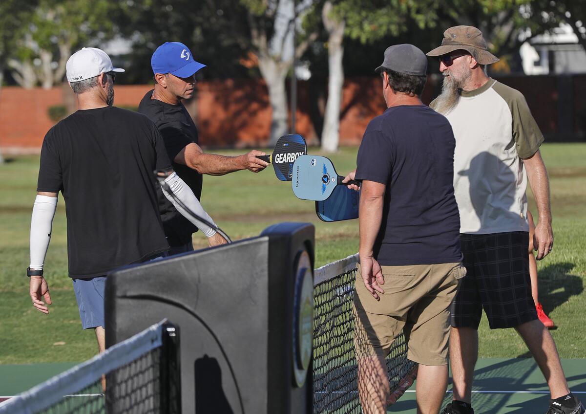 Pickleball players meet at the new courts at Tanager Park in Costa Mesa on Tuesday.