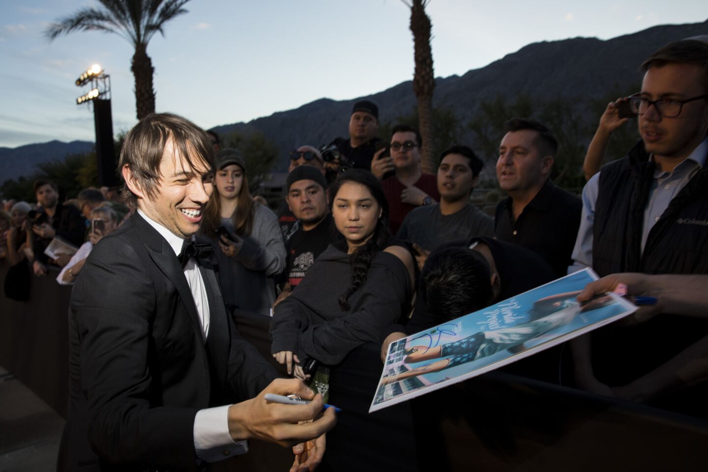 "The Florida Project" director Sean Baker signs autographs before hitting the red carpet of the Palm Springs International Film Festival Gala.