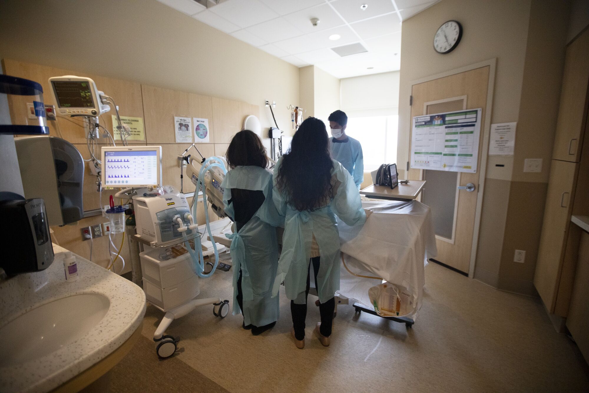 Marilou Harris, from left, and her children Michelle and Michael stand by Bob's bedside.