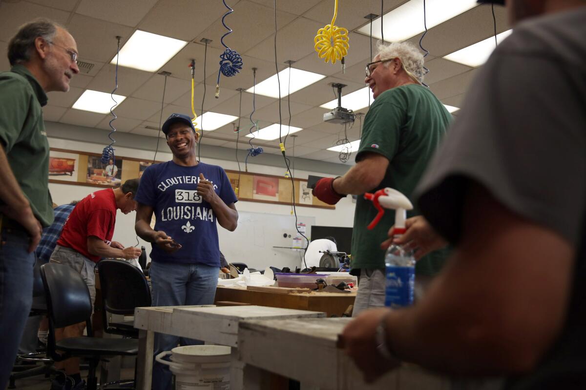 Greg Marris, center, chats with professor Carl Stammerjohn, left, and a classmate during a class titled "Woodworking With Hand Tools" at Cerritos College.