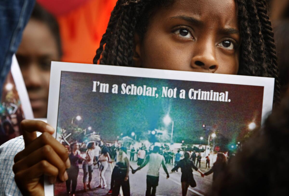 Folasade Aremu, who was then a freshman economics major, holds a photo during a 2013 sit-in on the USC campus to protest the LAPD's handling of the party.