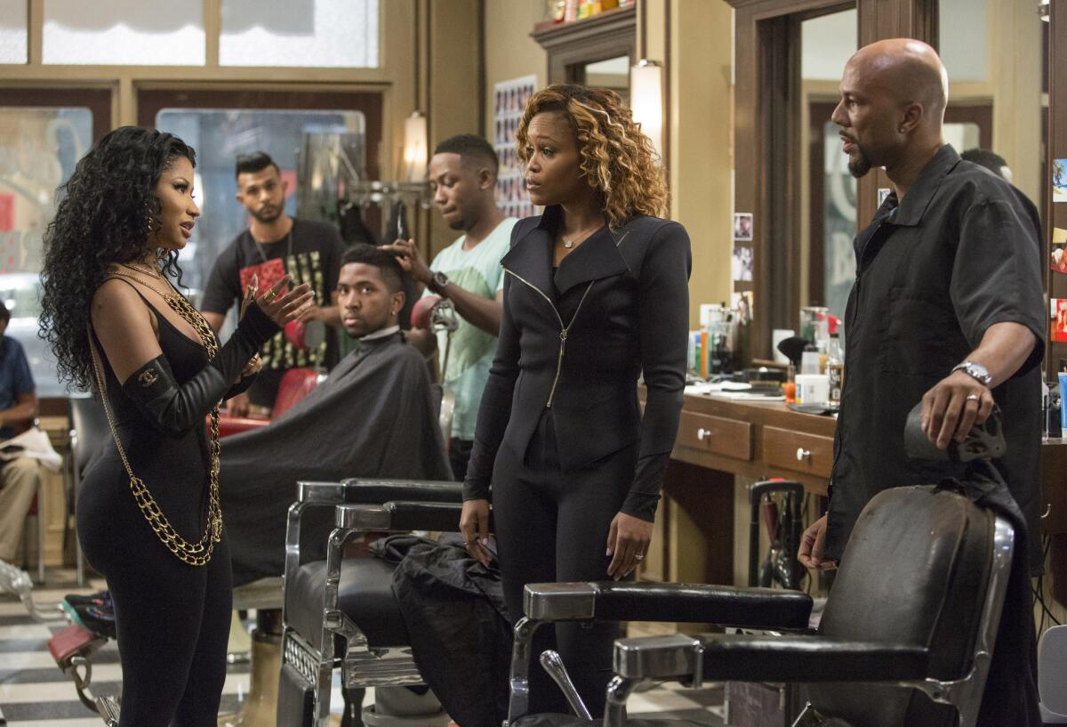 Nicki Minaj, foreground from left, Eve and Common appear in a scene from "Barbershop: The Next Cut."