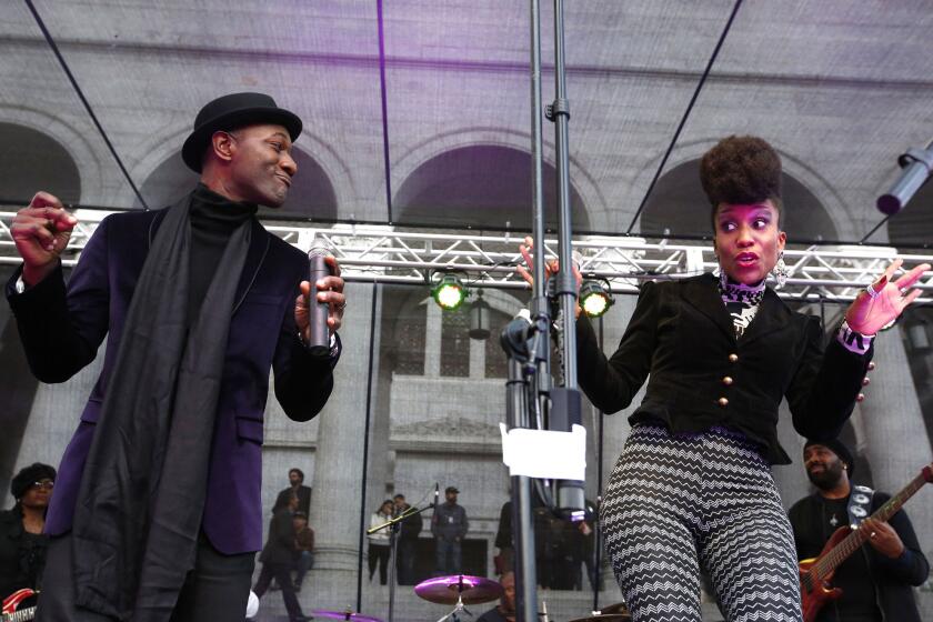 Aloe Blacc, left, performs for thousands at a public memorial for Prince outside L.A. City Hall.