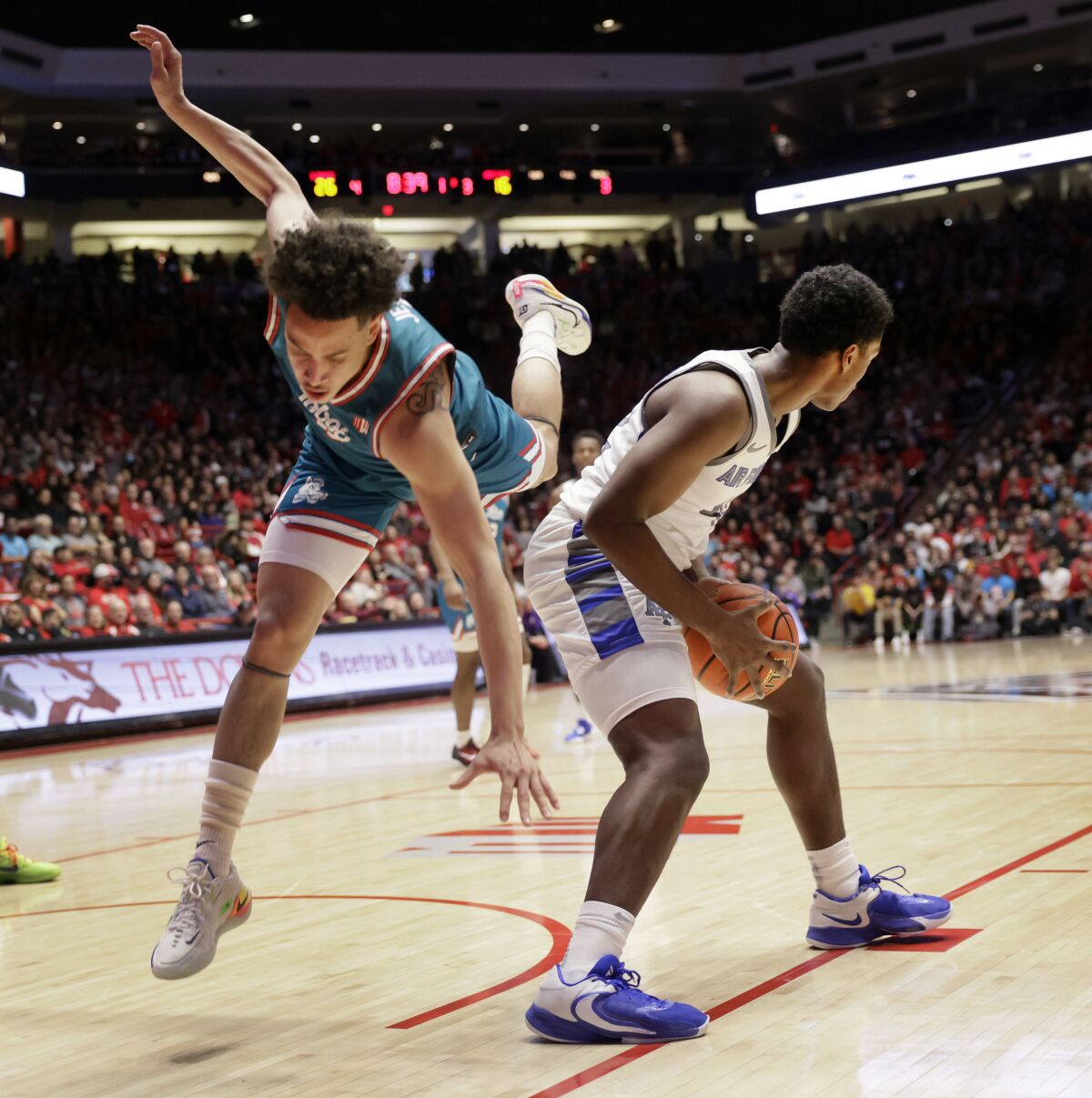 New Mexico's KJ Jenkins is thrown off balance while defending against Air Force guard Marcell McCreary during the first half of an NCAA college basketball game in Albuquerque, N.M., Friday, Jan. 27, 2023. (AP Photo/Eric Draper)