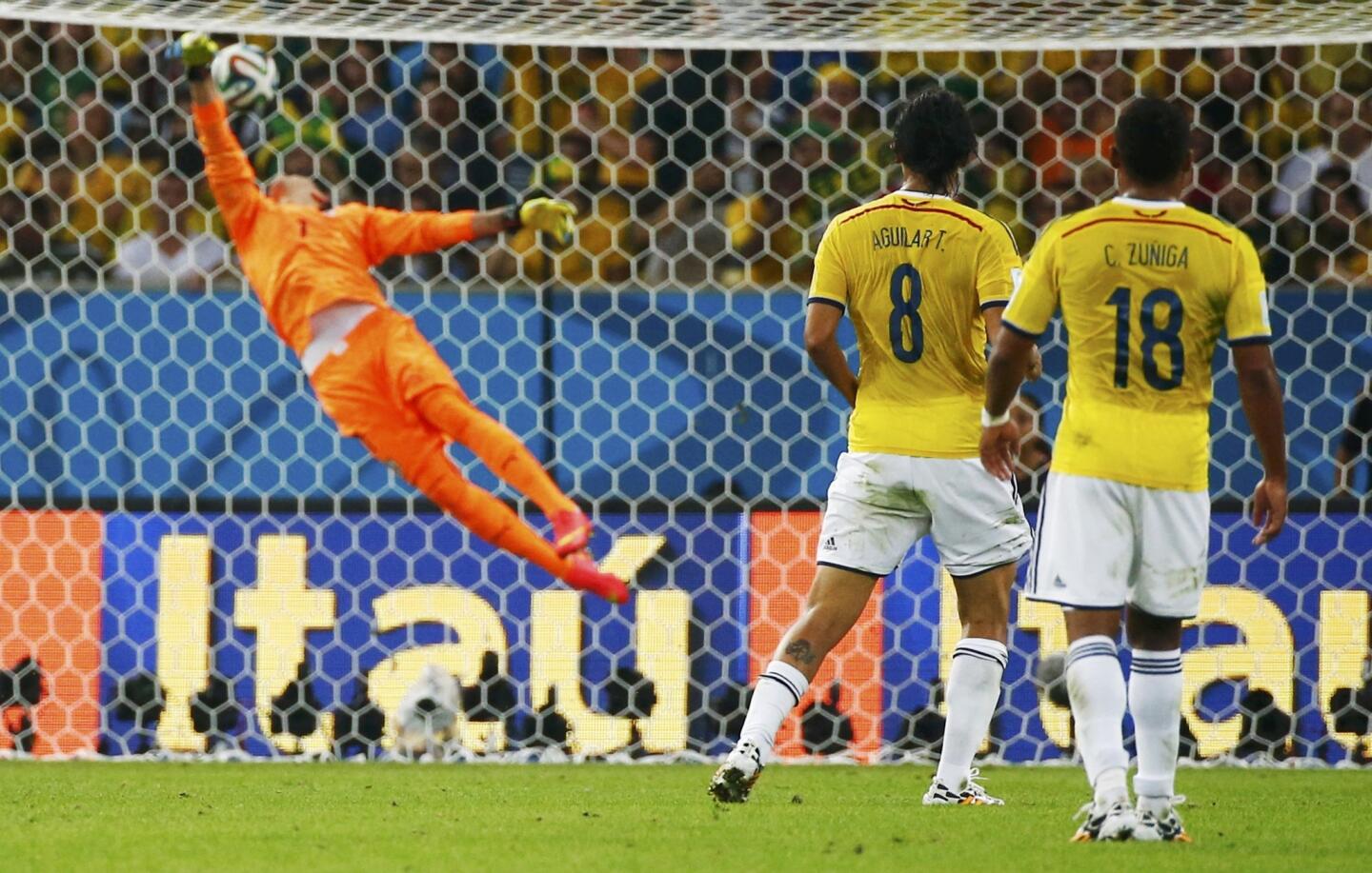 Colombia's Aguilar and Zuniga watch as James' volley beats Uruguay's Muslera to score during their 2014 World Cup round of 16 game at the Maracana stadium in Rio de Janeiro