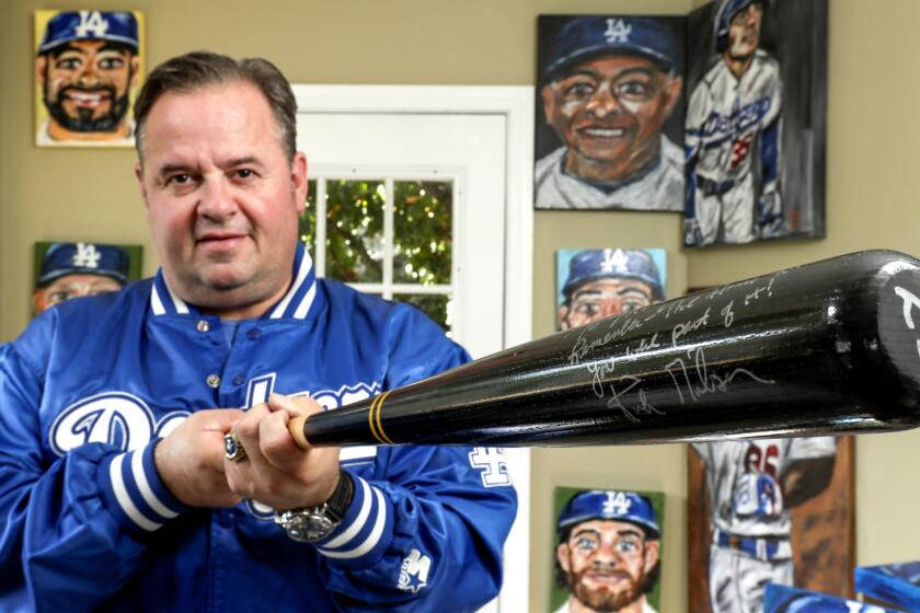 WEST COVINA CA OCTOBER 2!, 2017 --- Mitch Poole, former Dodger batboy who was the secret weapon behind Kirk Gibson's home run, holds a bat autographed by Gibson. Poole still works in Dodger visiting clubhouse. (Irfan Khan / Los Angeles Times)