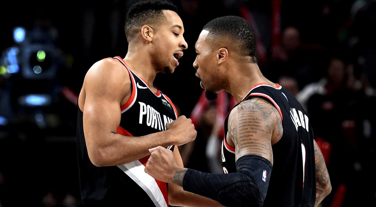 Trail Blazers guards C.J. McCollum, left, and Damian Lillard celebrate after McCollum made a three-pointer during a game against the Timberwolves.