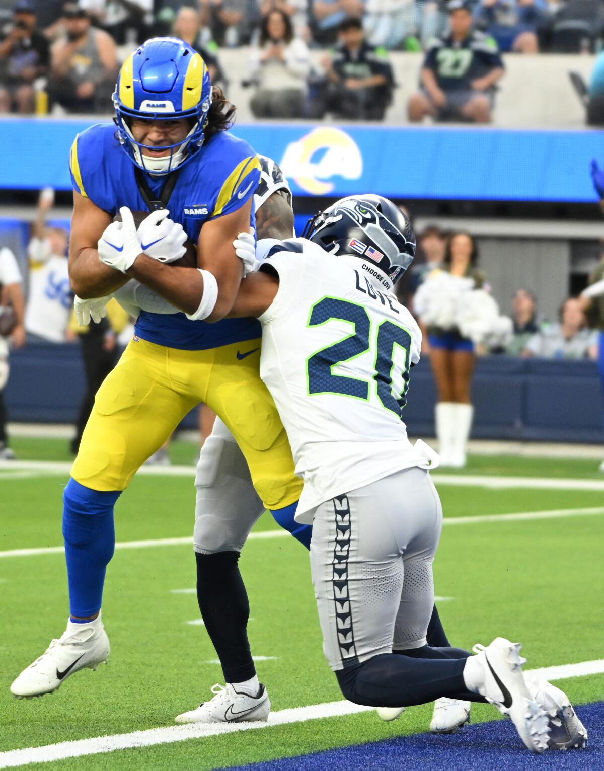 Rams wide receiver Puka Nacua pushes past Seattle Seahawks safety Julian Love to score a touchdown.
