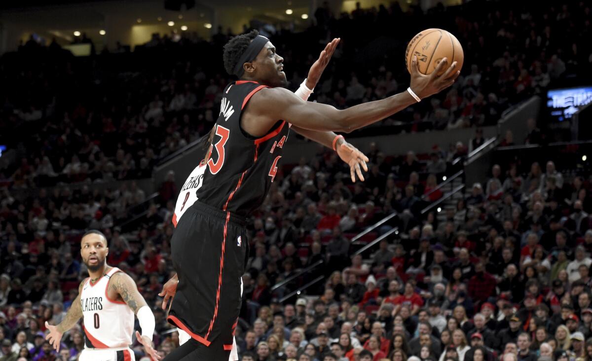 Toronto Raptors forward Pascal Siakam drives to the basket past Portland Trail Blazers forward Jerami Grant, obscure, during the first half of an NBA basketball game in Portland, Ore., Saturday, Jan. 28, 2023. (AP Photo/Steve Dykes)