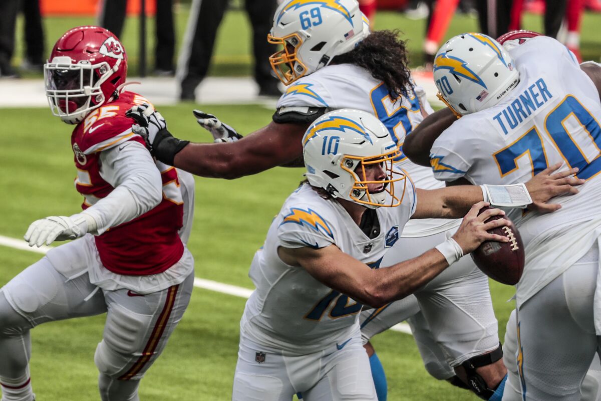 Chargers quarterback Justin Herbert scrambles against the Chiefs defense.