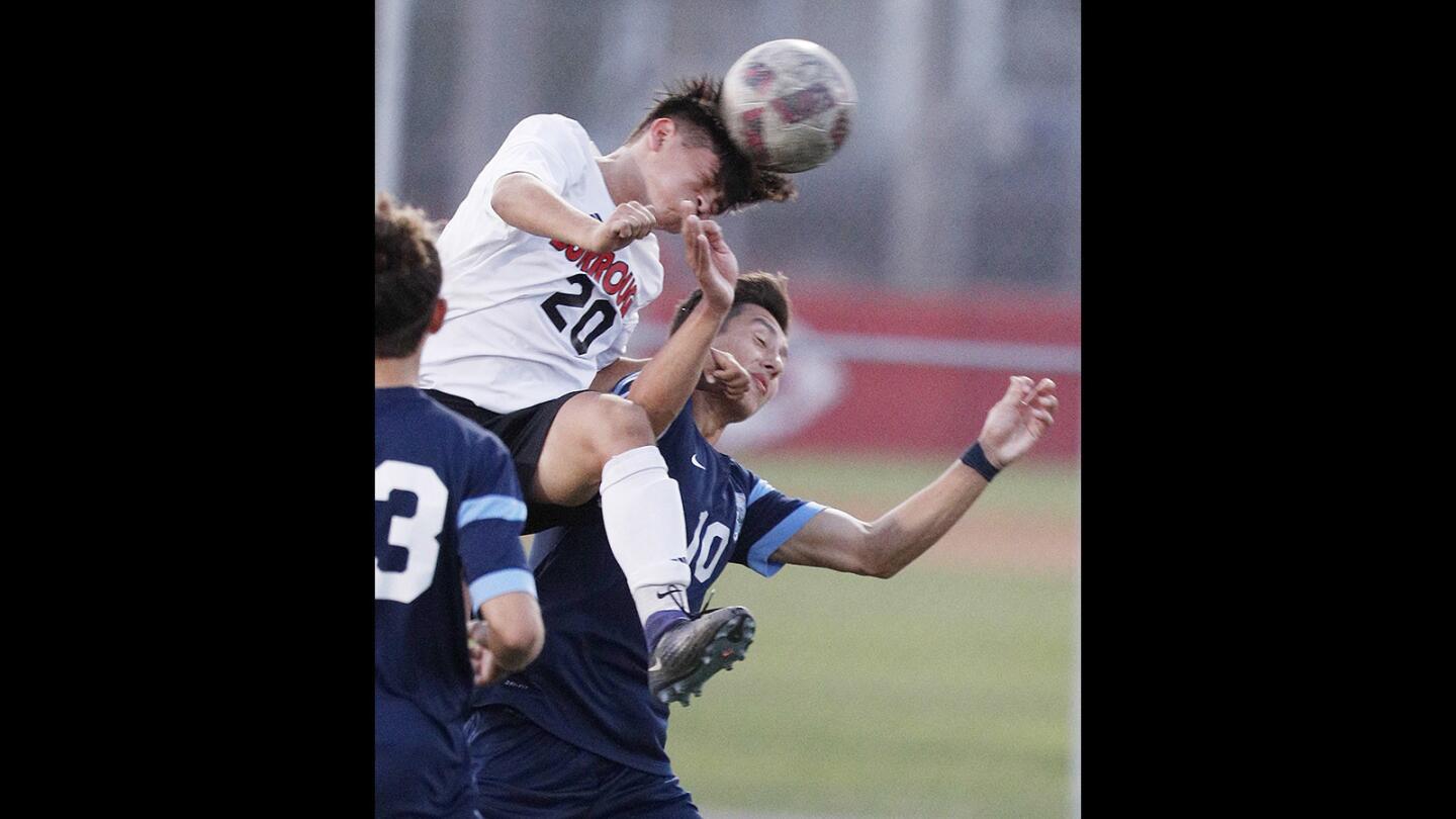 Burroughs' Carlos Rosales heads the ball over Crescenta Valley's Kyle Queseda in a Pacific League boys' soccer game at Burroughs High School on Friday, February 2, 2018.