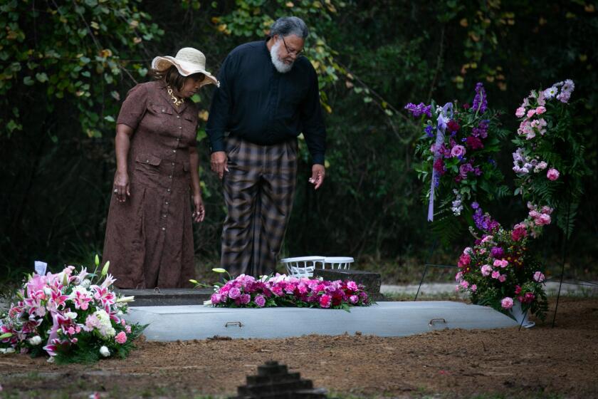 HAWTHORNE, FL - NOVEMBER 22: Pastor Albert Mann and his wife Valencia Mann visits grave of Dorthy Jackson the mother of Valencia who recently died from complications of Covid on Sunday, Nov. 22, 2020 in Hawthorne, FL. The Gordon Chapel Community Church cemetery is where several church members who died from Covid are buried. (Jason Armond / Los Angeles Times)