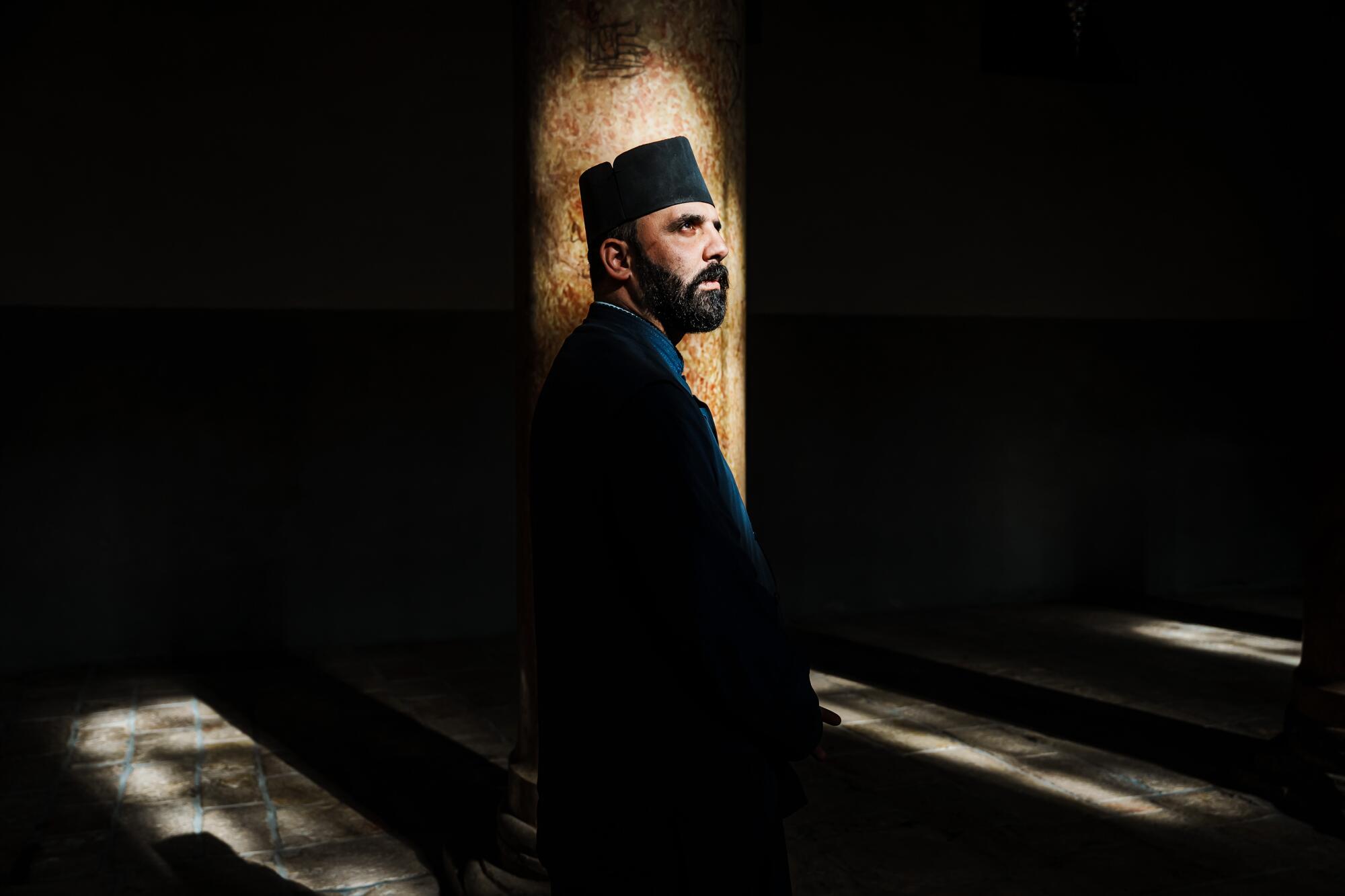 Father Issa Thaljieh poses for a portrait inside the Church of the Nativity in Bethlehem