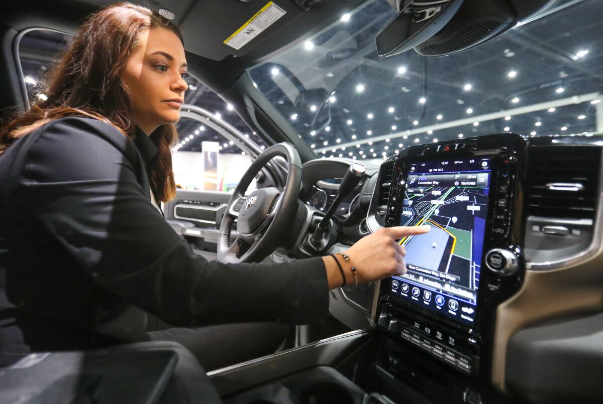A product specialist for Fiat Chrysler Automobiles demonstrates the 12-inch in-vehicle touchscreen display in a 2019 Ram 2500 Laramie Crew Cab 4x4 pickup truck during the 2020 San Diego International Auto Show Saturday.