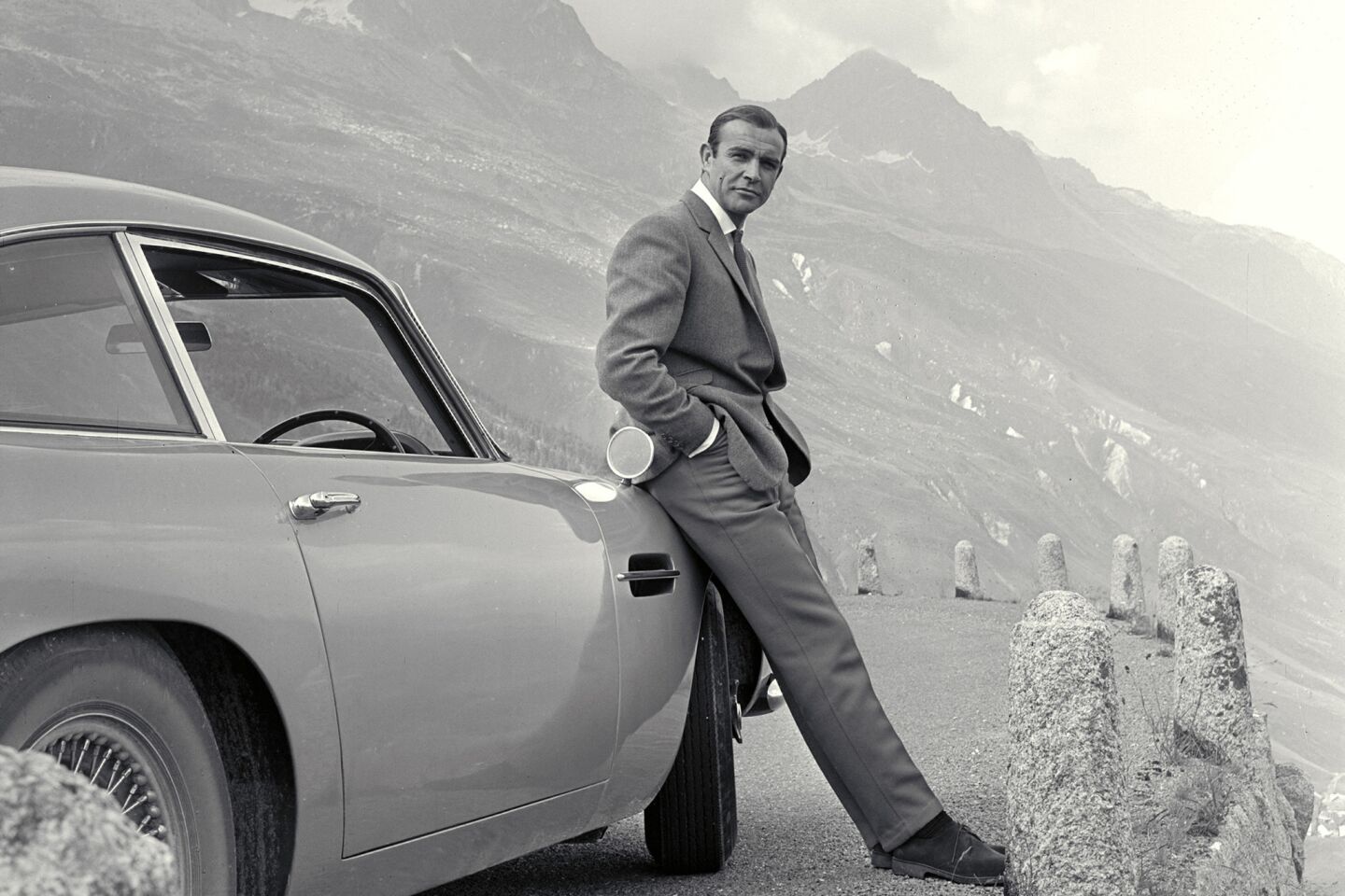 Sean Connery poses with his signature Aston Martin in the 1964 movie Goldfinger.