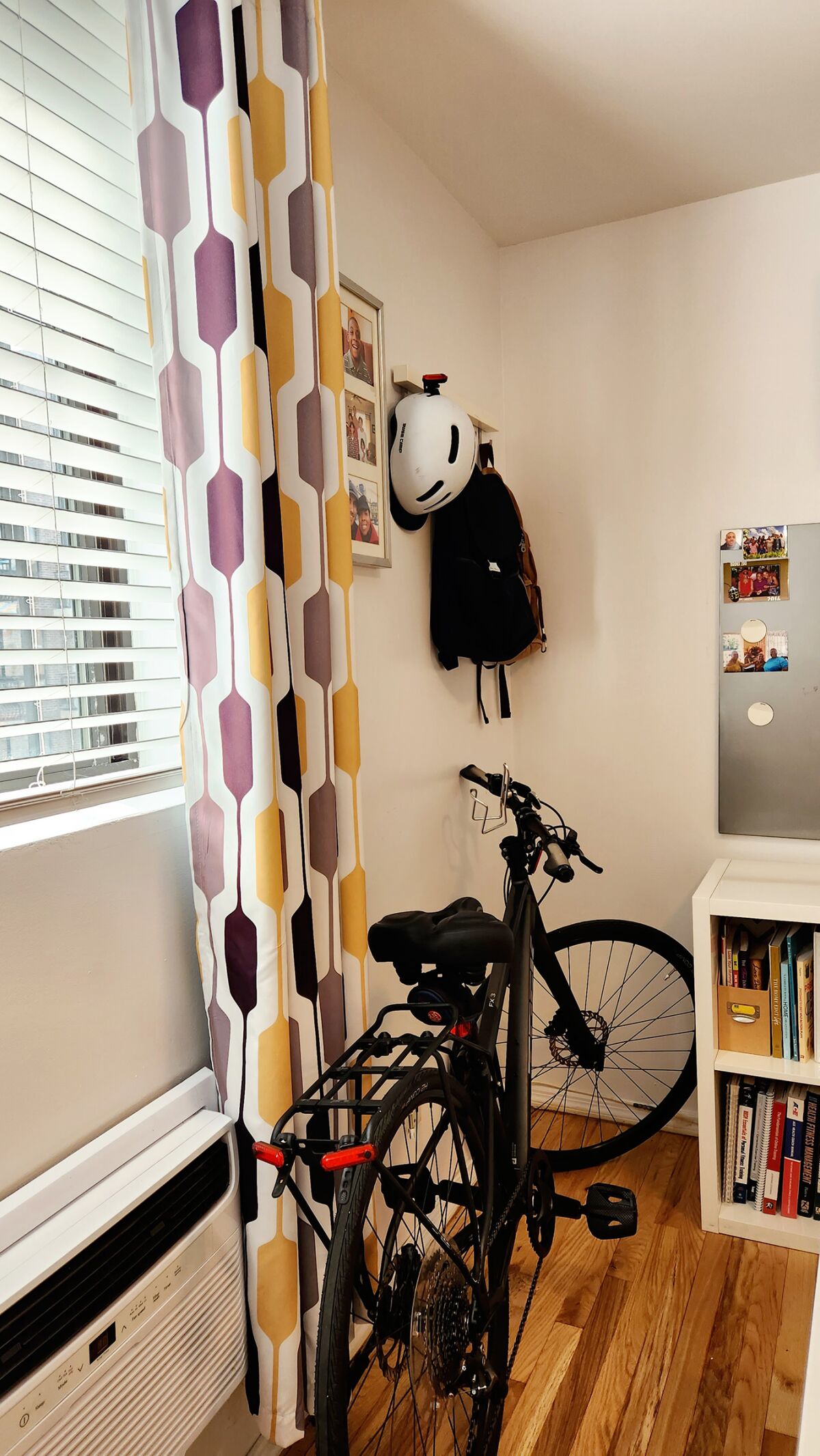 A bike is stored in the corner of a boy's bedroom, where it fits with the decor.