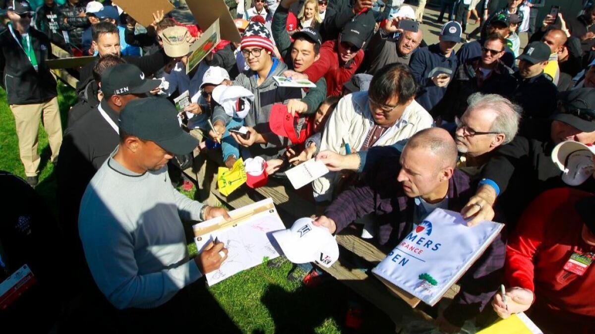 Tiger Woods signs autographs for fans following the Farmers Insurance Open Pro-Am on Jan. 25.