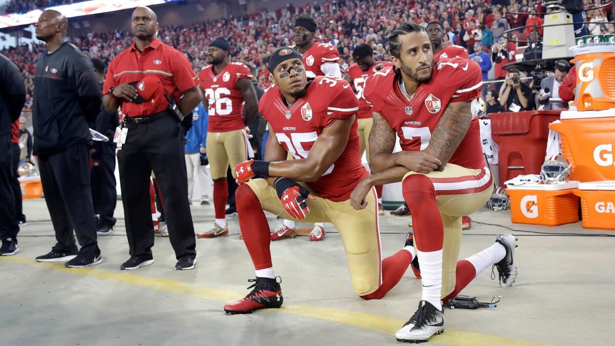 San Francisco 49ers safety Eric Reid and quarterback Colin Kaepernick kneel during the national anthem before their game against the Los Angeles Rams on Sept. 12, 2016.