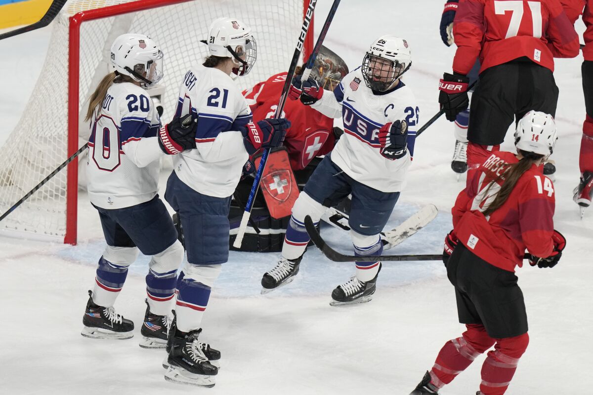 United States' Hilary Knight (21) is congratulated by Hannah Brandt (20) and Kendall Coyne Schofield (26) after scoring a goal against Switzerland during a preliminary round women's hockey game at the 2022 Winter Olympics, Sunday, Feb. 6, 2022, in Beijing. (AP Photo/Petr David Josek)