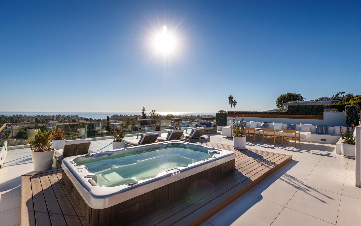 A rooftop deck with a hot tub