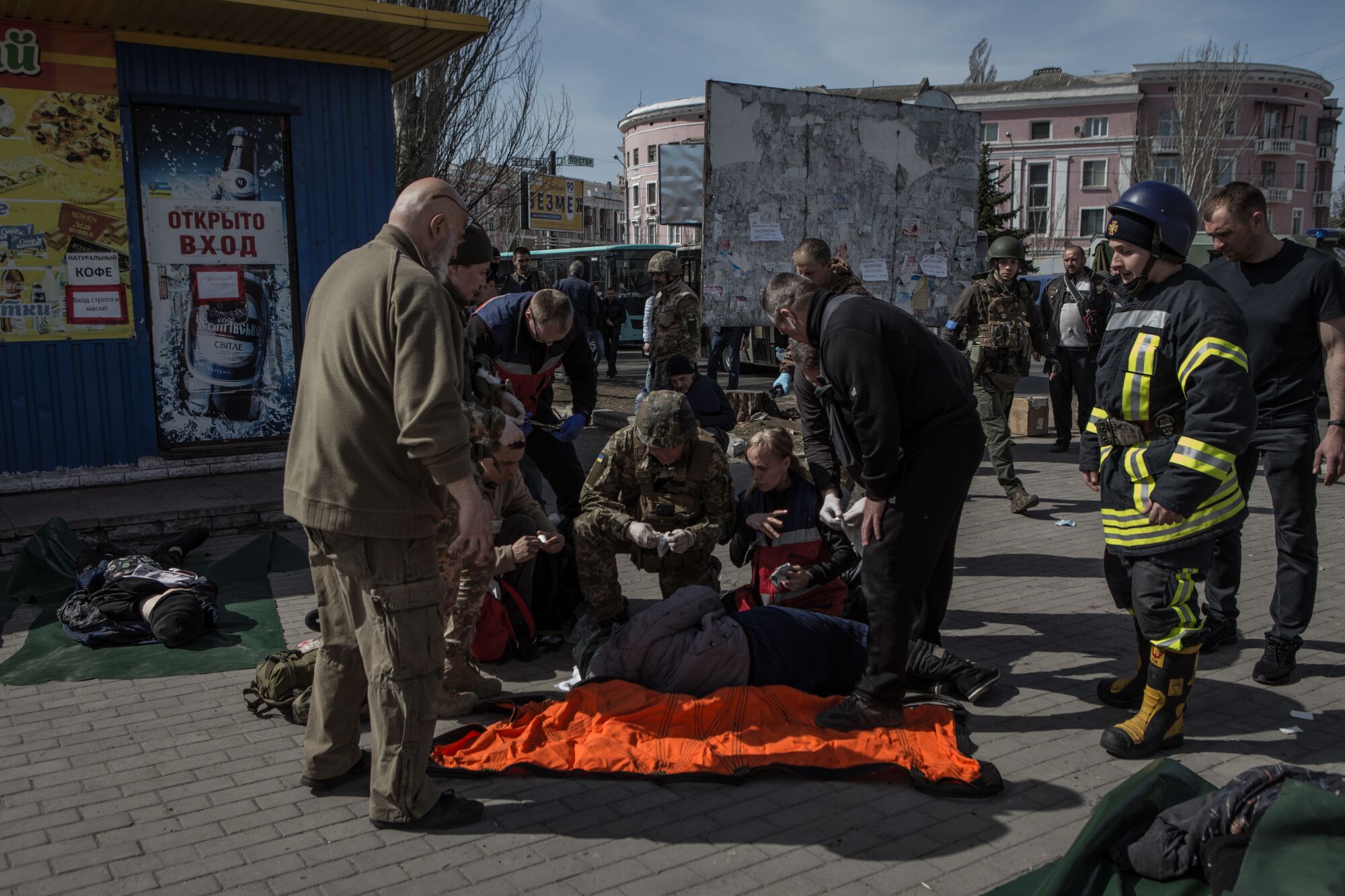 People gather around a person on the ground after Friday's rocket attack on a train station in eastern Ukraine.