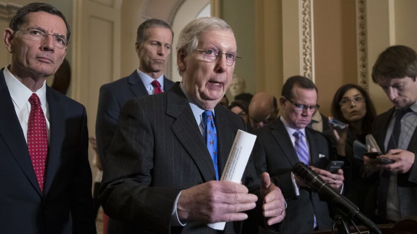 Senate Majority Leader Mitch McConnell (R-Ky.), center, joined from left by Sens. John Barrasso (R-Wyo.) and John Thune (R-S.D.), speaks to reporters Dec. 18 at the Capitol.