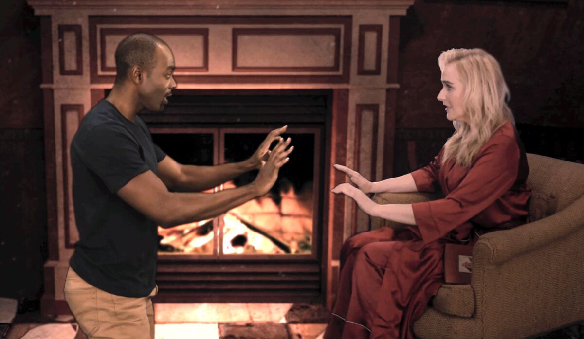 Actors Clifton Duncan and Betsy Wolfe in front of a fireplace in the filmed musical "Estella Scrooge."
