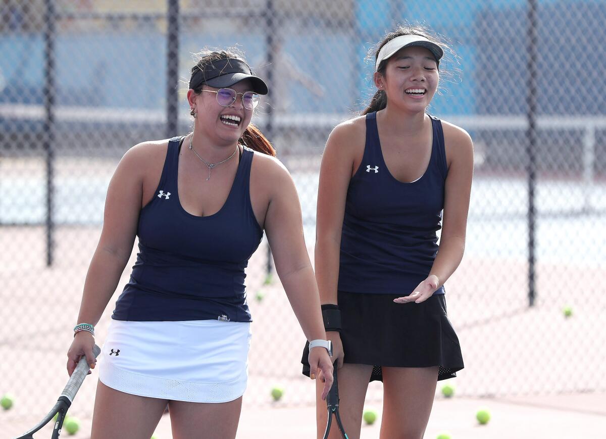 Fountain Valley girls' tennis players Melody Hom and Rene Do, from left, share a laugh during practice.