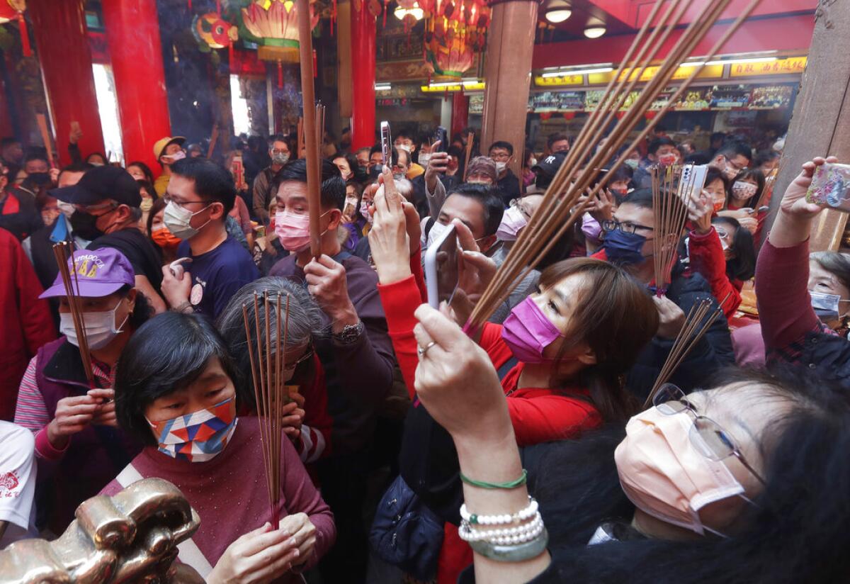 Fieles con mascarillas para evitar contagios de coronavirus rezan en un templo 