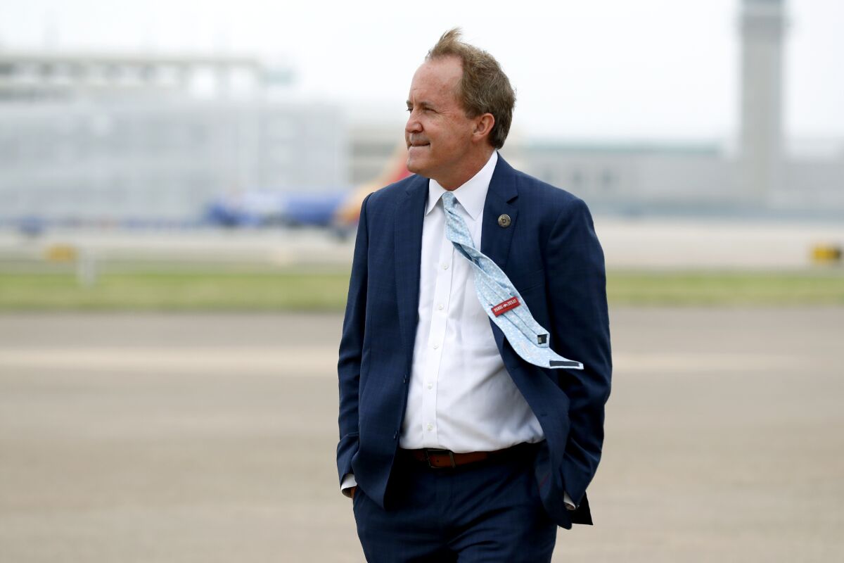 FILE - In this June 28, 2020, file photo, Texas Attorney General Ken Paxton waits on the flight line for the arrival of Vice President Mike Pence at Love Field in Dallas. Paxton had an extramarital affair with a woman whom he later recommended for a job with the wealthy donor now at the center of criminal allegations against him, according to two people who said Paxton told them about the relationship. (AP Photo/Tony Gutierrez, File)