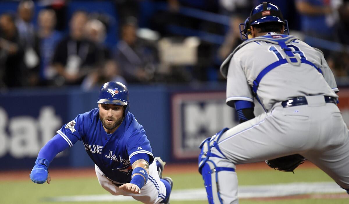 Toronto Blue Jays' Kevin Pillar dives for home plate in front of Kansas City Royals catcher Salvador Perez during the second inning of Game 3 of the ALCS on Monday.