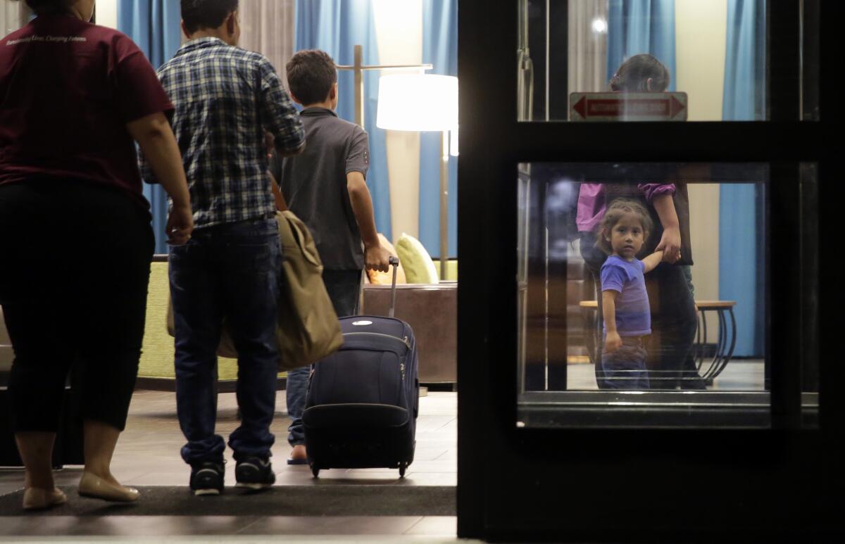 FILE - Immigrants seeking asylum who were recently reunited arrive at a hotel in San Antonio, July 23, 2018. (AP Photo/Eric Gay, File)