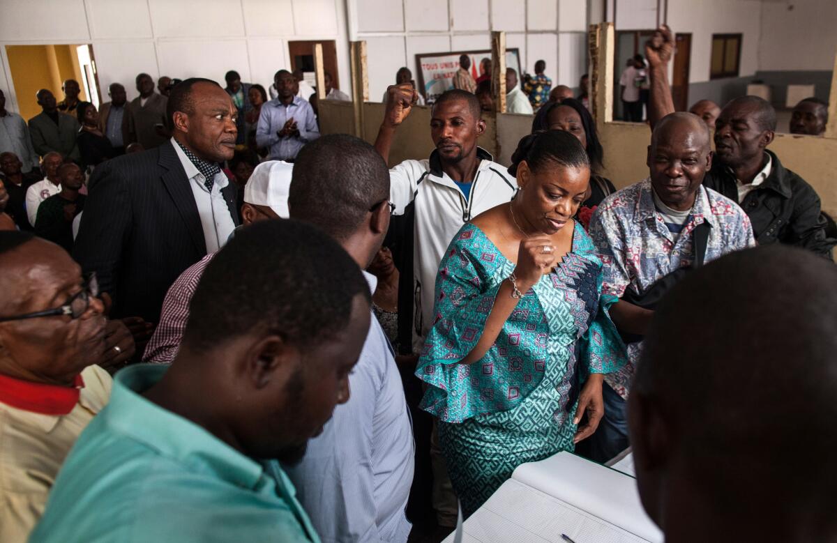 Congolese Member of Parliament and MLC party General Secretary Eve Bazaiba pumps her fist while fellow party members cheer, after she was the first to add her name to the official petition for the presidential candidacy of Jean-Pierre Bemba in Kinshasa, on Aug. 23, 2018.
