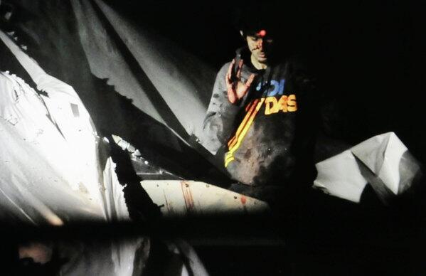 Nineteen-year-old Boston Marathon bombing suspect Dzhokhar Tsarnaev, bloody and disheveled with the red dot of a sniper's rifle laser sight on his forehead, raises his hand from inside a boat at the time of his capture by law enforcement authorities in Watertown, Mass.