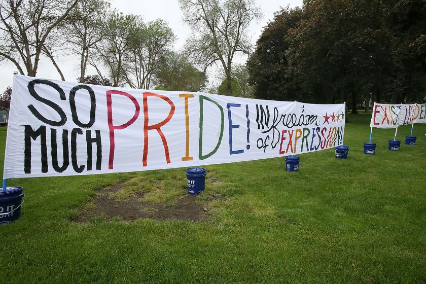 A sign celebrating the North Idaho Pride Alliance's Pride in the Park event is displayed at City Park in Coeur d'Alene, Idaho, Saturday, June 11, 2022. A northern Idaho drag performer is suing a far-right blogger for defamation because he says the blogger released a doctored video that falsely made it look as if he exposed himself to children. Eric Posey filed the lawsuit this week alleging his reputation was damaged after Summer Bushnell released the doctored video on her blog and falsely told her followers that Posey had committed a felony during a Pride festival in Coeur d'Alene. (Devin Weeks/Coeur D'Alene Press via AP)