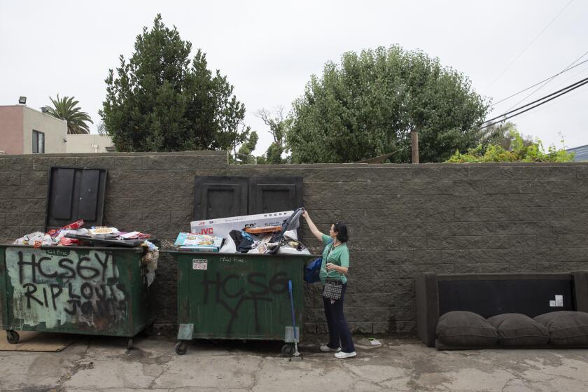 Amber Elizabeth Stevens reaches into a dumpster for salvageable items on Thursday, August 22, 2019 in Long Beach, Calif. After one day seeing someone who Òpractically threw away their whole house,Ó Stevens committed to a life of reusing what others do not want. (Liz Moughon / Los Angeles Times)