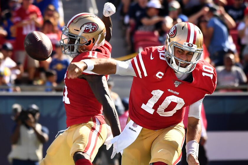 LOS ANGELES, CALIFORNIA OCTOBER 13, 2019-49ers quarterback Jimmy Garoppolo (10) spikes the ball after scoring a touchdown against the Rams in the 3rd quarter at the Coliseum Sunday. (Wally Skalij/Los Angeles Times)