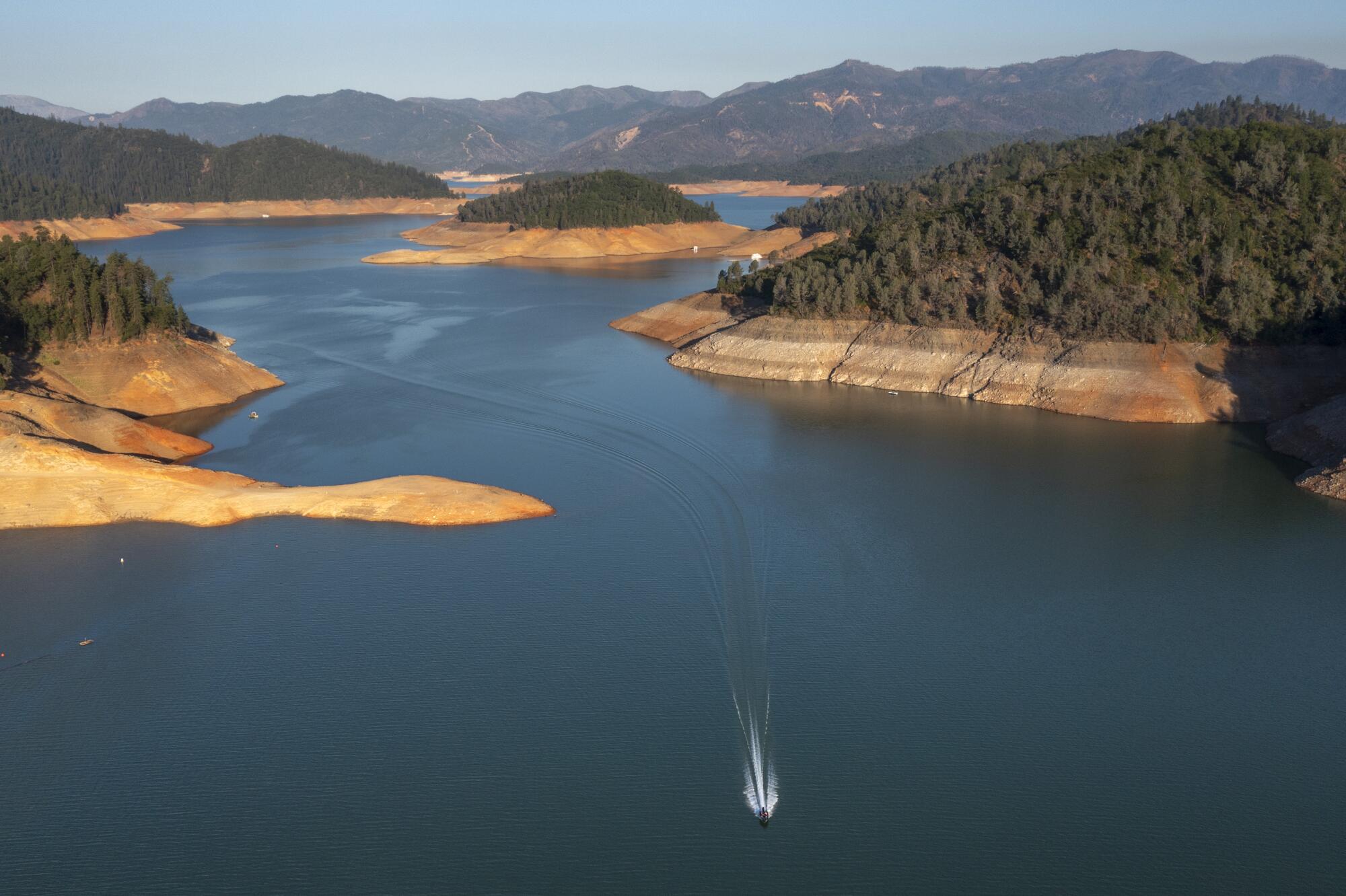 Bare dirt and rocks exposed as the water level has fallen form a "bathtub ring" around Lake Shasta