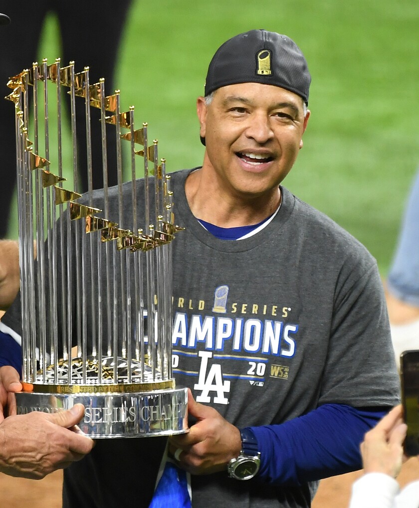 Dodgers manager Dave Roberts holds the championship trophy after Game 6 of the World Series.