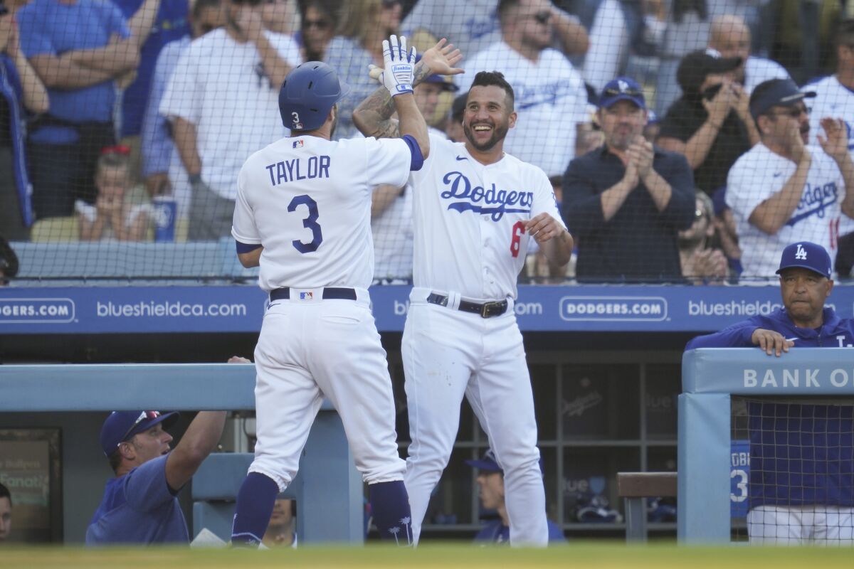 The Dodgers' Chris Taylor celebrates with David Peralta after scoring on Miguel Vargas ' seventh-inning triple June 3, 2023. 