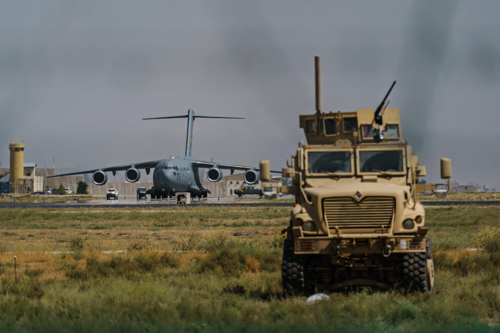 A truck sits near the airport where a large plane prepares to take off.